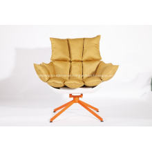 white husk chair with orange seat cushion